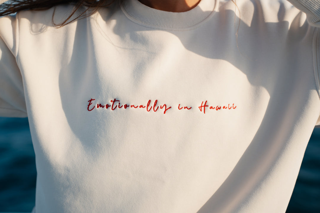 אישה על יאכטה לובשת סוויטשירט לבן עם טקסט – מראה שמשדר קלילות, חופש וסטייל ייחודי, בדיוק כמו כל פריט ב-Lika Swimwear שמלווה אותך ברגעים המיוחדים שלך על המים והחוף.