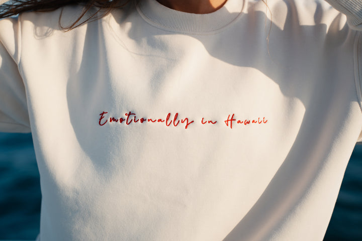 אישה על יאכטה לובשת סוויטשירט לבן עם טקסט – מראה שמשדר קלילות, חופש וסטייל ייחודי, בדיוק כמו כל פריט ב-Lika Swimwear שמלווה אותך ברגעים המיוחדים שלך על המים והחוף.